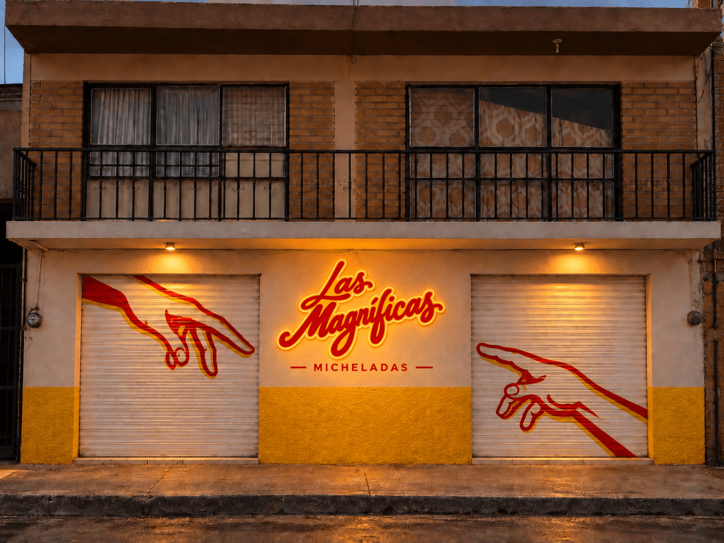 Fachada de Las Magníficas de noche, con el letrero iluminado